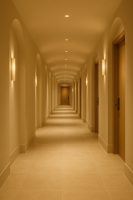 ممر فندقي مضاء بلطف يبرز فلسفة المعمار الهادئ والسكينة البصرية